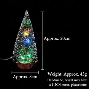 Detail showing 20cm mini snow-dusted Christmas tree with LED lights and wooden base