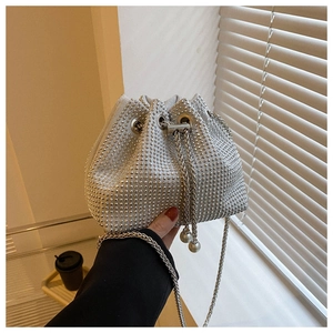 Detail of silver rhinestone bucket bag with drawstring closure and elegant pearl accents