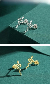 Detailed macro of S925 sterling silver snake earrings in gold and silver finishes