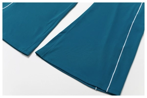 Détail du pantalon de yoga bleu foncé montrant les bandes blanches et la couture de l'ourlet