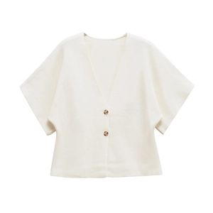 Detail of cream-white knitted cardigan featuring gold cylindrical buttons and a V-neckline