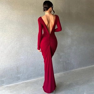 Detail of elegant red long sleeve dress featuring backless deep V design and ruching