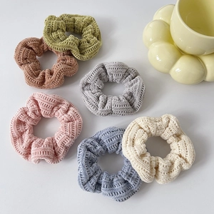 Set of six colorful textured knit hair scrunchies in autumn tones on white background