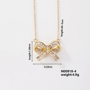 Detailed view of a gold bow pendant necklace with sparkling pavé-set crystals and dimensions