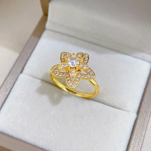 Detailaufnahme eines rotierenden Goldblumenrings mit weißen Diamanten auf Samt-Schmuckkästchen