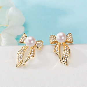 Elegant bow knot earrings with white freshwater pearls and sparkling zircons on gold base
