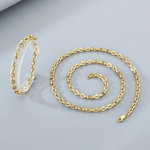 Polished gold jewelry set with interlocking links on a minimalist display stand