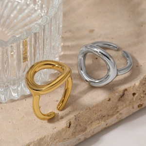 Minimalist adjustable open rings in gold and silver finish on natural stone background
