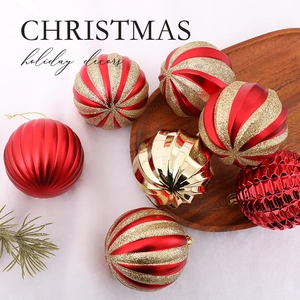 Red and gold Christmas tree ball ornaments with various textures on a wooden tray