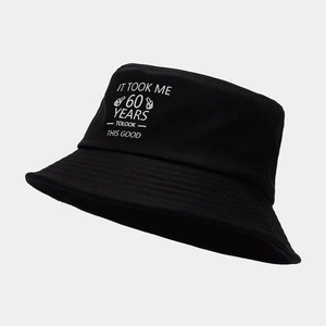 Detail of black cotton bucket hat with white 60th birthday printed text slogan