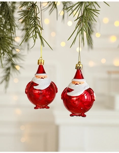 Close-up of Santa Claus hanging ornaments on pine branches with warm bokeh lighting