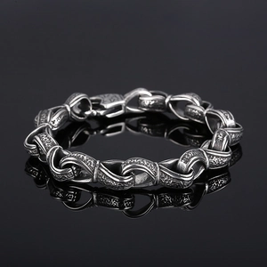 Detail of vintage oxidized titanium steel chain bracelet with textured links and glossy reflection