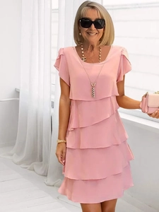 Detailed view of layered tiered pink summer dress with pleated chiffon ruffles and crew neck