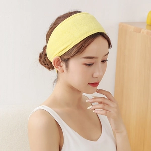 Macro detail of yellow absorbent terry cloth headband on model for skincare and yoga