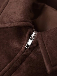 Detail eines silbernen Metallreißverschlusses an einer braunen Wildlederjacke