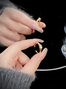 Close-up of golden adjustable ring with a sparkling white zircon on model's finger