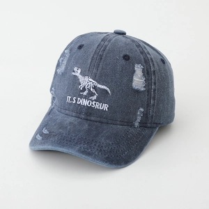 Detail of distressed navy denim baseball cap featuring white dinosaur skeleton embroidery