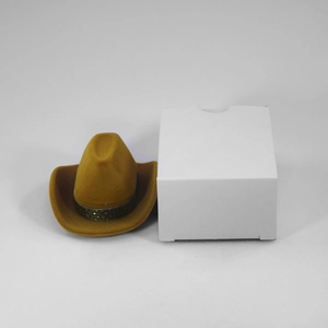 Detail of a brown faux suede cowboy hat jewelry box next to a white square packaging box