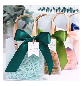 Detail of frosted gift bags with colorful silk ribbons and Happy Teacher's Day tags