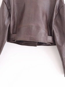 Detailed macro view of dark brown faux leather jacket hem with belt loops and stitching