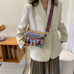 Close-up of bohemian woven crossbody bag with colorful tassels and geometric strap