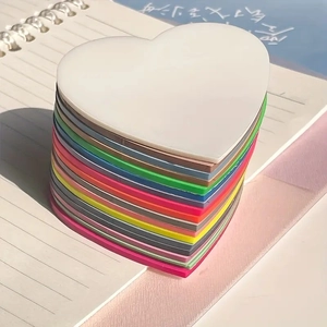 Stack of colorful heart-shaped acrylic sticky notes on a spiral notebook in bright sunlight