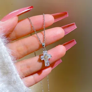 Detailed view of cross pendant featuring baguette zircons and a small golden center cross