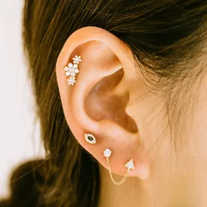 Detail view of 925 sterling silver ear piercing set with gold plating and white zircons