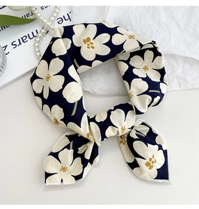 Detail view of navy blue floral cotton scarf with white flowers on a white desktop