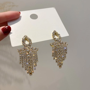 Sparkling geometric tassel earrings in gold with white rhinestones and long fringe
