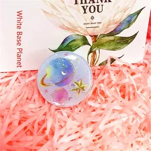 Detail of dreamlike purple starry planet phone socket grip on pink raffia background