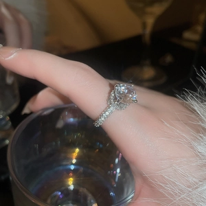 Detailed close-up of a luxury silver ring with a large round zircon and pavé diamonds