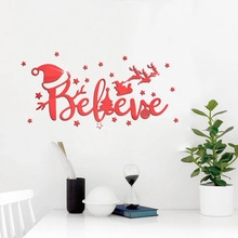 Christmas wall decal with Believe text, Santa sleigh, and stars on a white wall