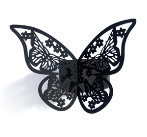 Close-up of laser-cut black butterfly napkin ring with intricate hollow patterns