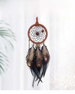 Detail of dreamcatcher car hanging with feathers, retro metal bells and wooden beads