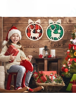 Detail view of round wooden Christmas ornaments with reindeer silhouettes and buffalo plaid fabric