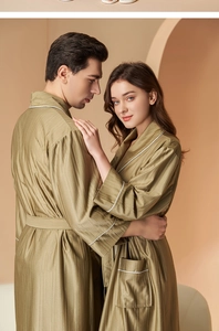 Detailed view of the striped fabric texture and white piping on this olive green bathrobe
