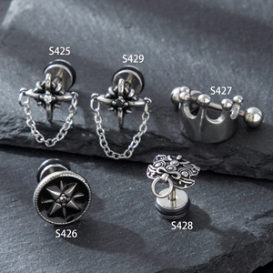 Stainless steel crown and star chain earrings set displayed on a dark grey stone slate