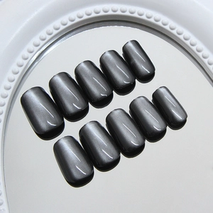 Chic black cat-eye press-on nails in medium coffin shape displayed on a pearl mirror tray