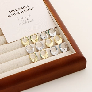 Gros plan de boucles d'oreilles en argent sterling en forme de U avec zircons colorés en boîte