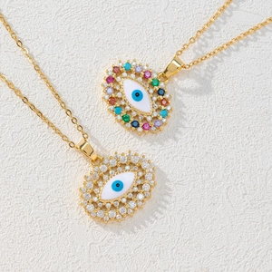 Dettaglio di collane Evil Eye placcate in oro con zirconi colorati su trama in pietra