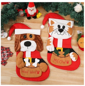 Detailed view of red plush Christmas stockings with 3D cat and dog motifs on wood floor