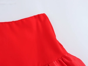 Détail de la taille élastique rouge et du tissu satiné lisse sur une mini-jupe