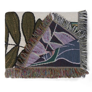 Detail of bohemian jacquard woven blanket showing intricate patterns and colorful fringe edges