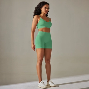 Detail eines smaragdgrünen Yoga-Sets mit geripptem Sport-BH und nahtloser Short