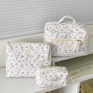 Detailed set of three floral quilted cotton makeup bags with pink rose patterns