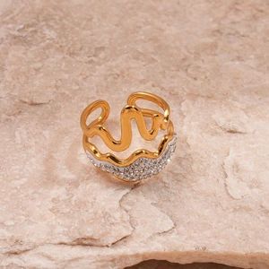 Detailed view of gold wave ring with white enamel and micro-set cubic zirconia accents