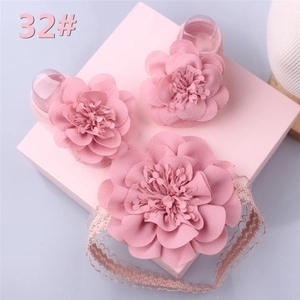 Detail of pink lace baby headband and matching floral soft-sole shoes in a gift box