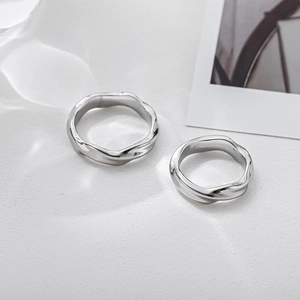 Set di anelli Mobius minimalisti in argento con finitura a specchio su sfondo bianco