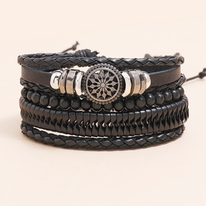 Set of four stacked black leather bracelets with braided ropes and metal sun charm